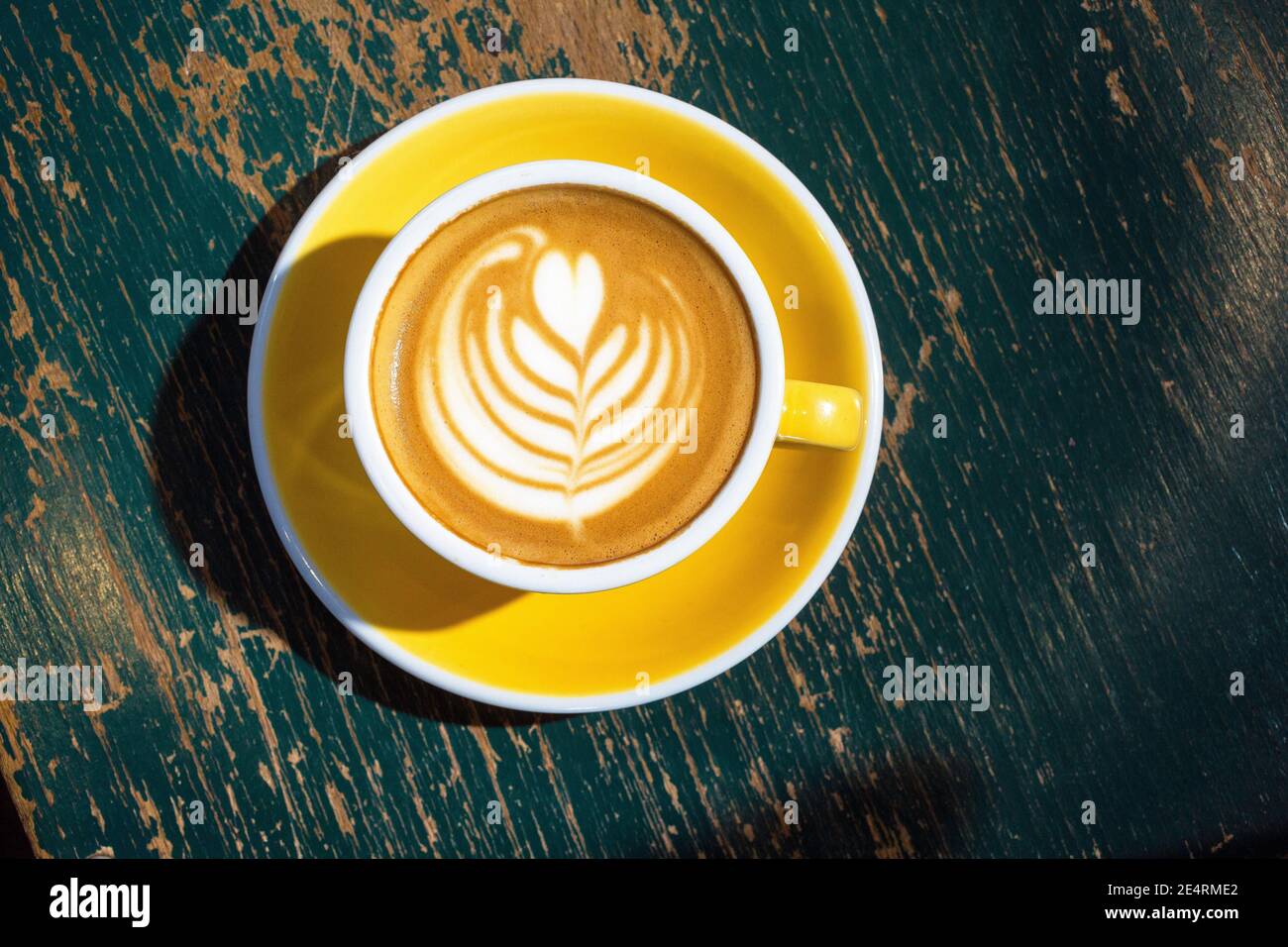 Direkt über Aussicht auf Kaffee mit Latte Art auf Tisch Stockfoto