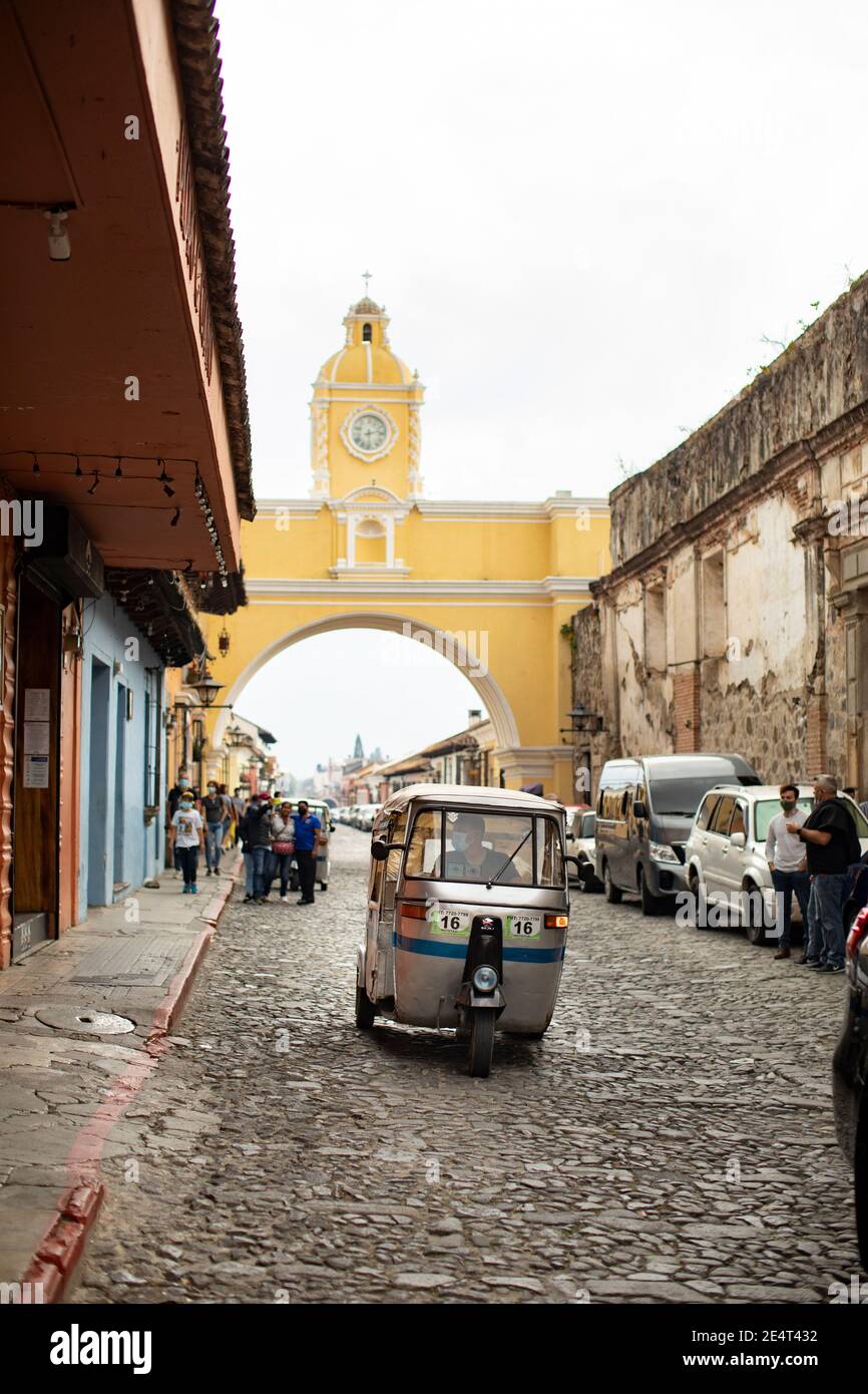 Tuk-Tuk öffentlichen Verkehrsmitteln Fahrzeug durch die Santa Catalina Arch in Antigua, Guatemala, Mittelamerika Stockfoto