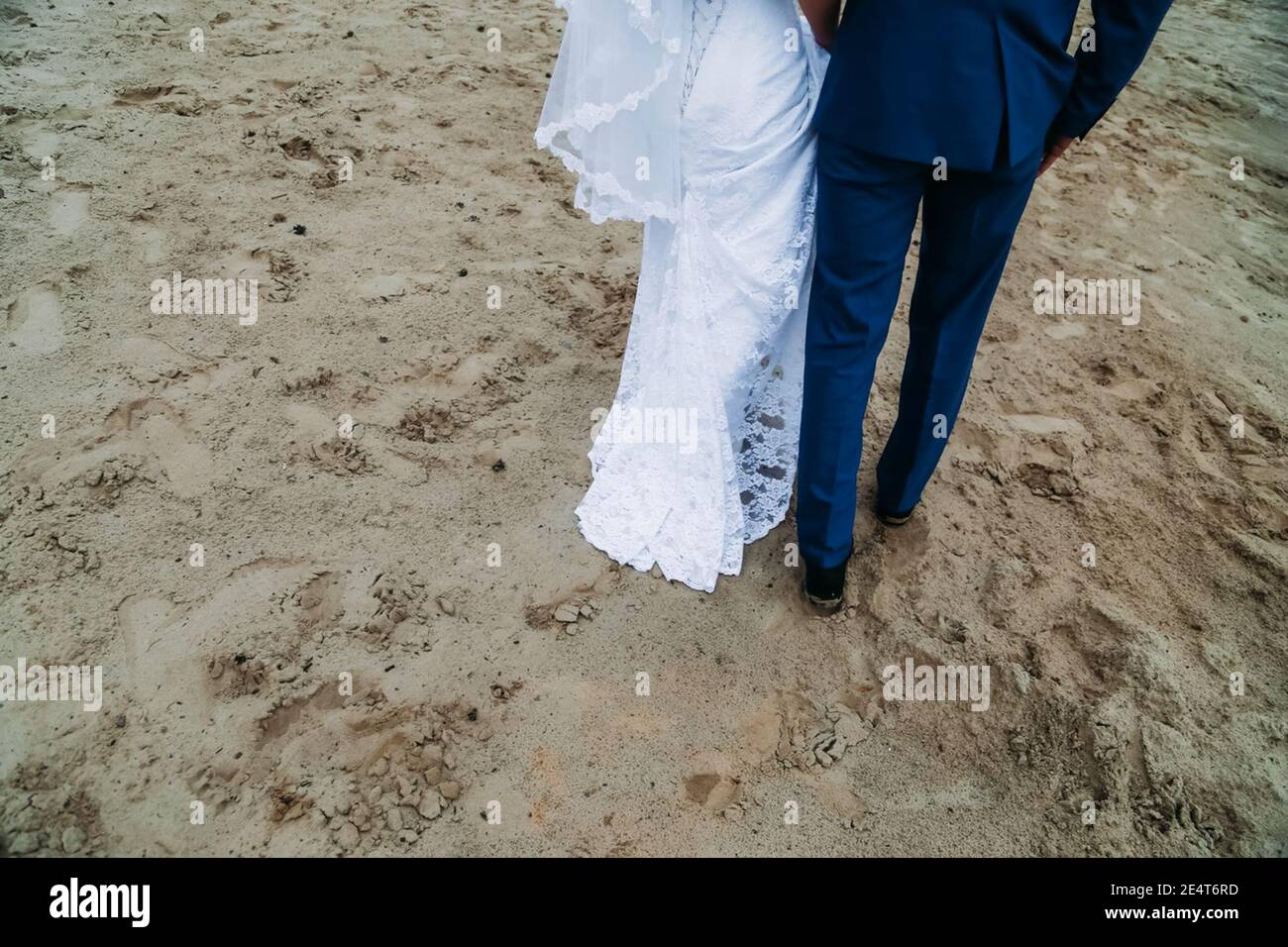 Braut und Bräutigam laufen auf dem Sand. Spaziergang entlang der Küste Stockfoto