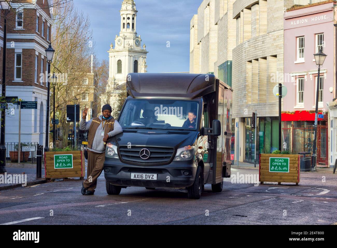 UPS Lieferung Fahrer Pose für Foto von UPS LKW fahren Durch Straßenpflanzer reserviert für Rettungswagen in London Stockfoto