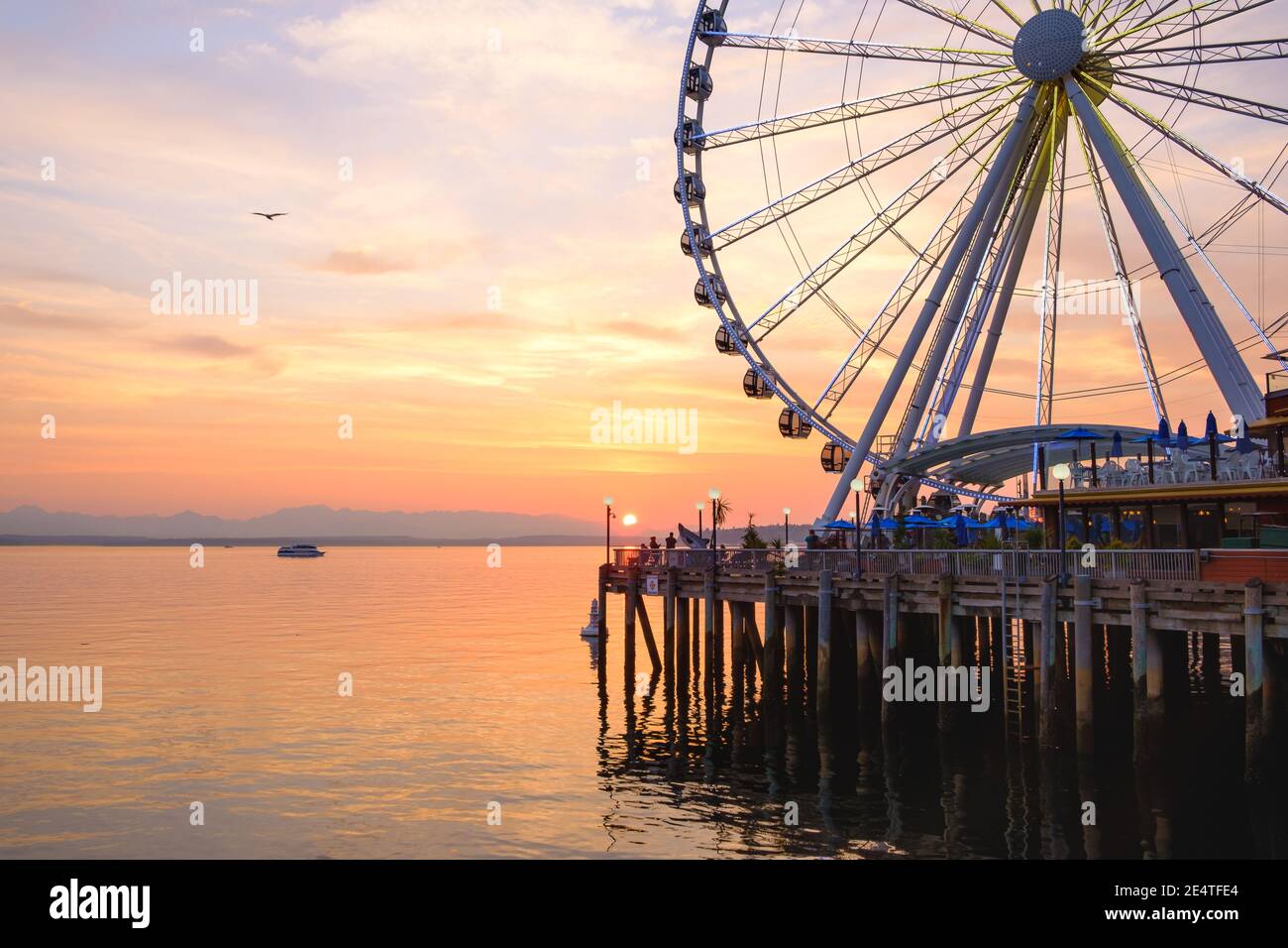 Das Seattle Great Wheel steigt 175 Meter über Pier 57, mit Blick auf die Skyline von Seattle und Elliott Bay, wenn die Sonne im Westen untergeht Stockfoto