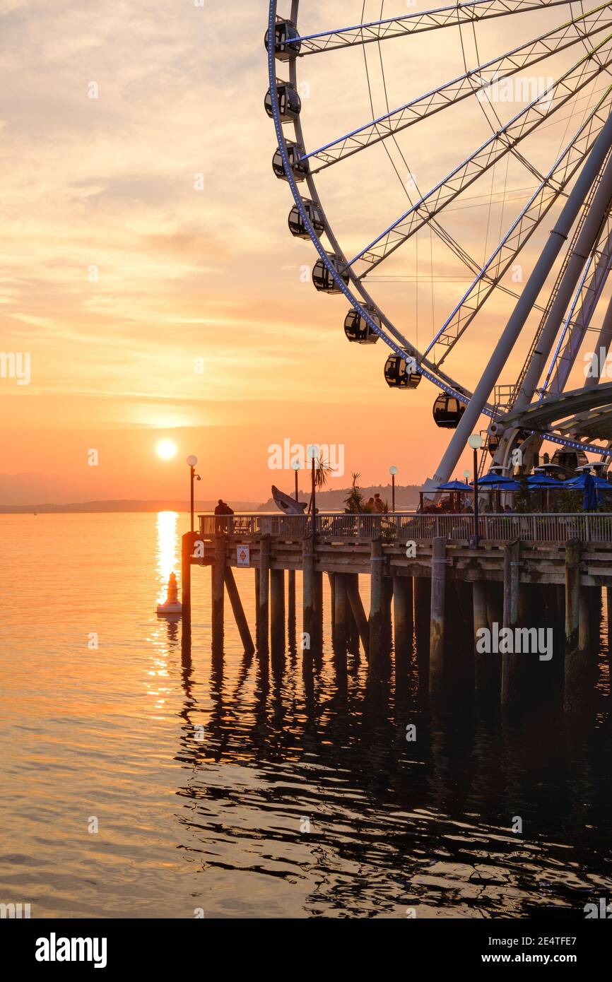 Das Seattle Great Wheel steigt 175 Meter über Pier 57, mit Blick auf die Skyline von Seattle und Elliott Bay, wenn die Sonne im Westen untergeht Stockfoto