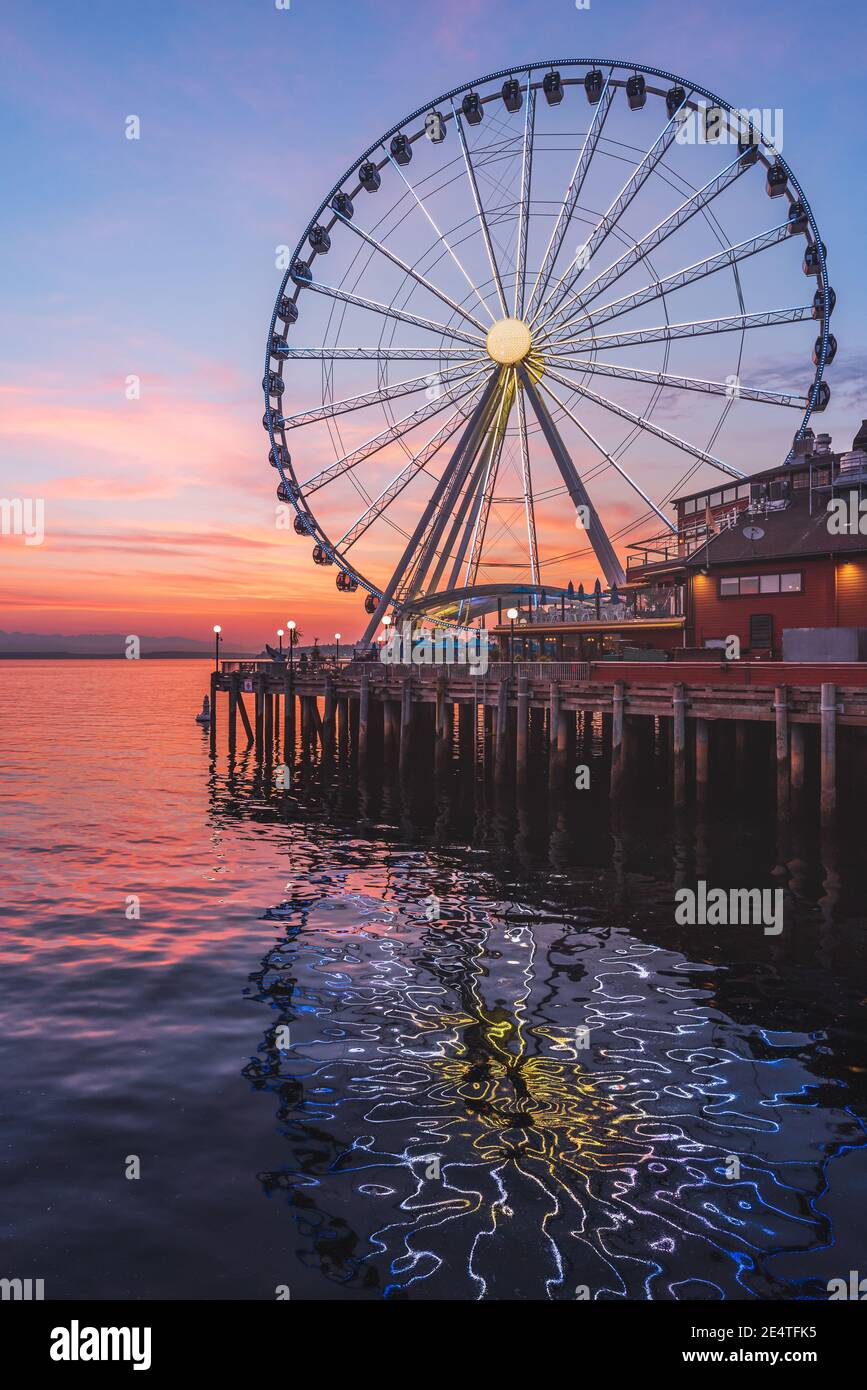 Das Seattle Great Wheel steigt 175 Meter über Pier 57, mit Blick auf die Skyline von Seattle und Elliott Bay, wenn die Sonne im Westen untergeht Stockfoto