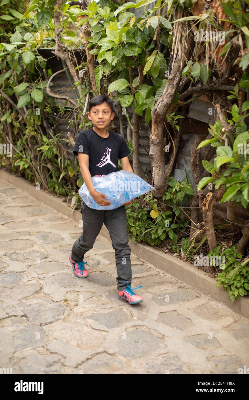 Gereinigtes Wasser in Plastiktüten und Kannen auf den Straßen von San Juan la Laguna, Guatemala, Mittelamerika verkauft. Stockfoto