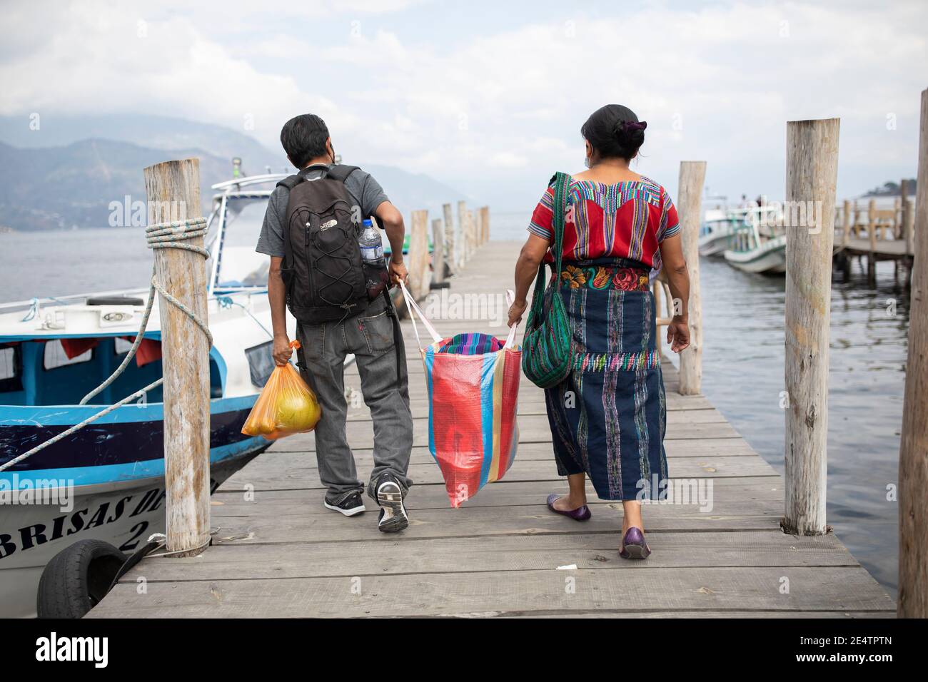 Die Passagiere bereiten sich auf das Einsteigen in eine Fähre vor, inmitten einer wunderschönen Landschaft auf dem See Atitlán, Guatemala, Mittelamerika. Stockfoto