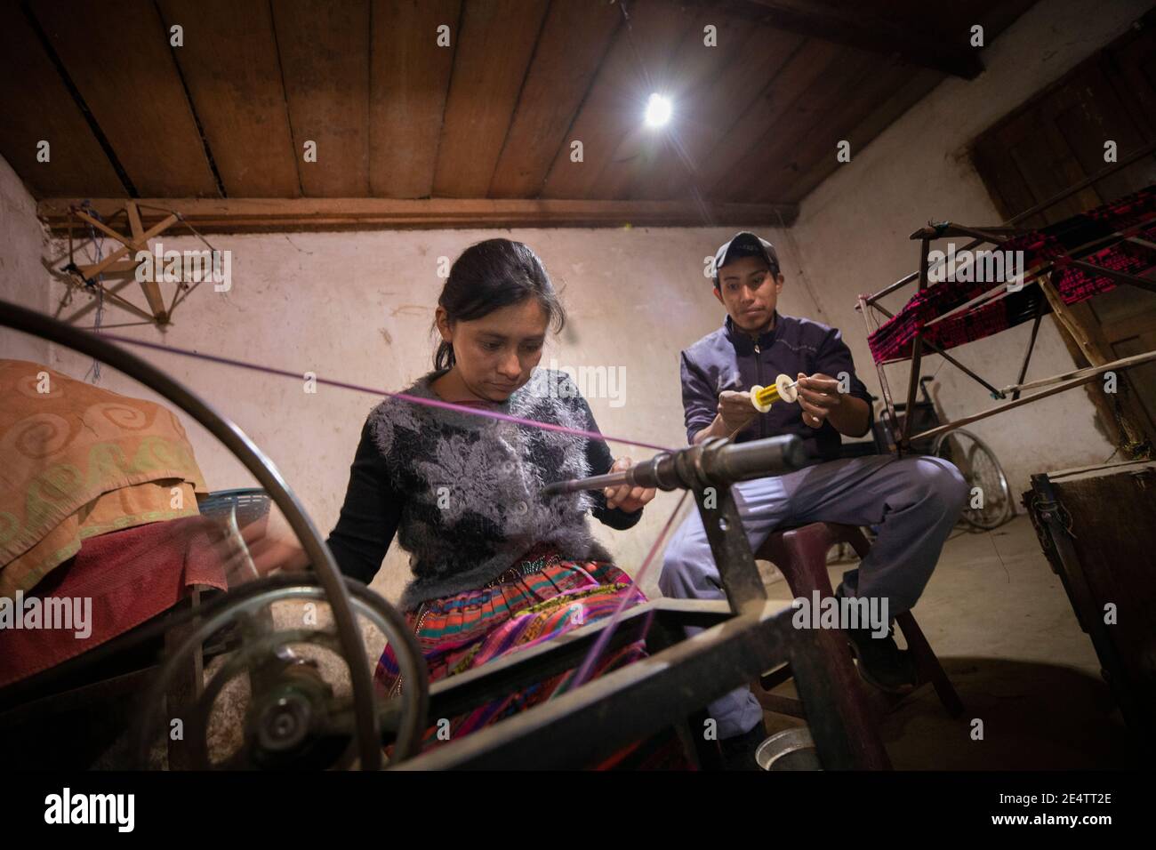 Familie, die ein neues solarbetriebenes Beleuchtungssystem in ihrem Zuhause in Cantel, Guatemala, Mittelamerika, verwendet. Stockfoto