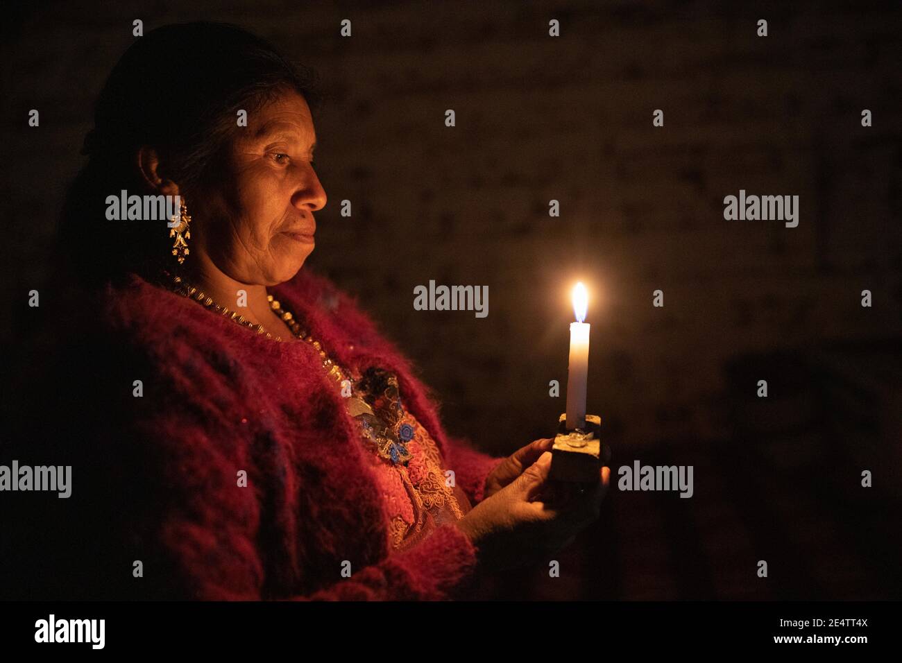 Eine Frau benutzt eine Kerze als Lichtquelle in ihrem Haus in Cantel, Guatemala, Mittelamerika. Stockfoto