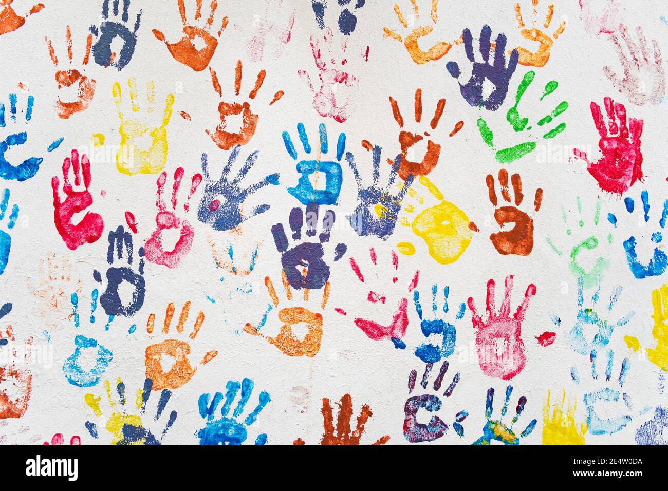Weiße Wand mit bunten bunten bunten Handdrucken. Stockfoto