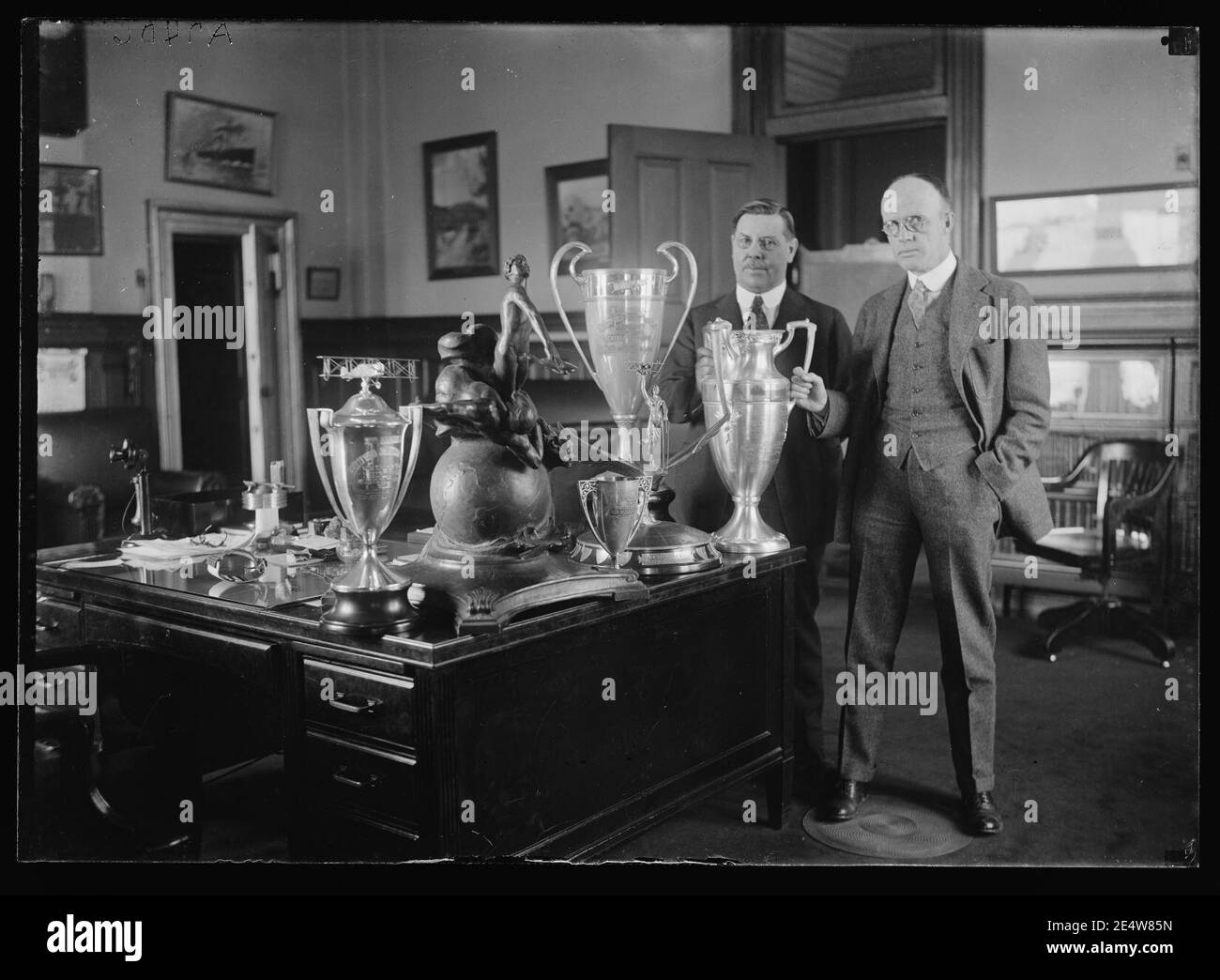 Männer mit Trophy Cups auf Schreibtisch Stockfoto