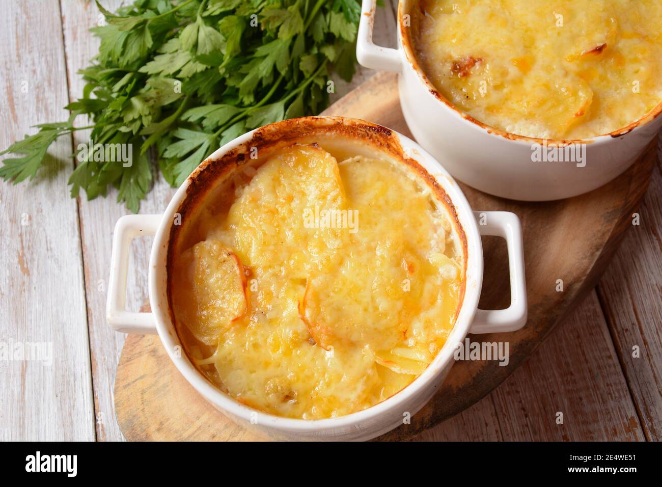 Kartoffelgratin in gebackenem weißem Kokotte Stockfoto
