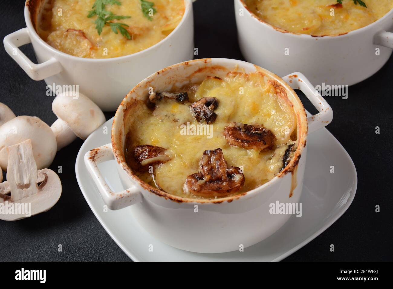 Kartoffelgratin mit Pilzen in Backkokotten Stockfoto