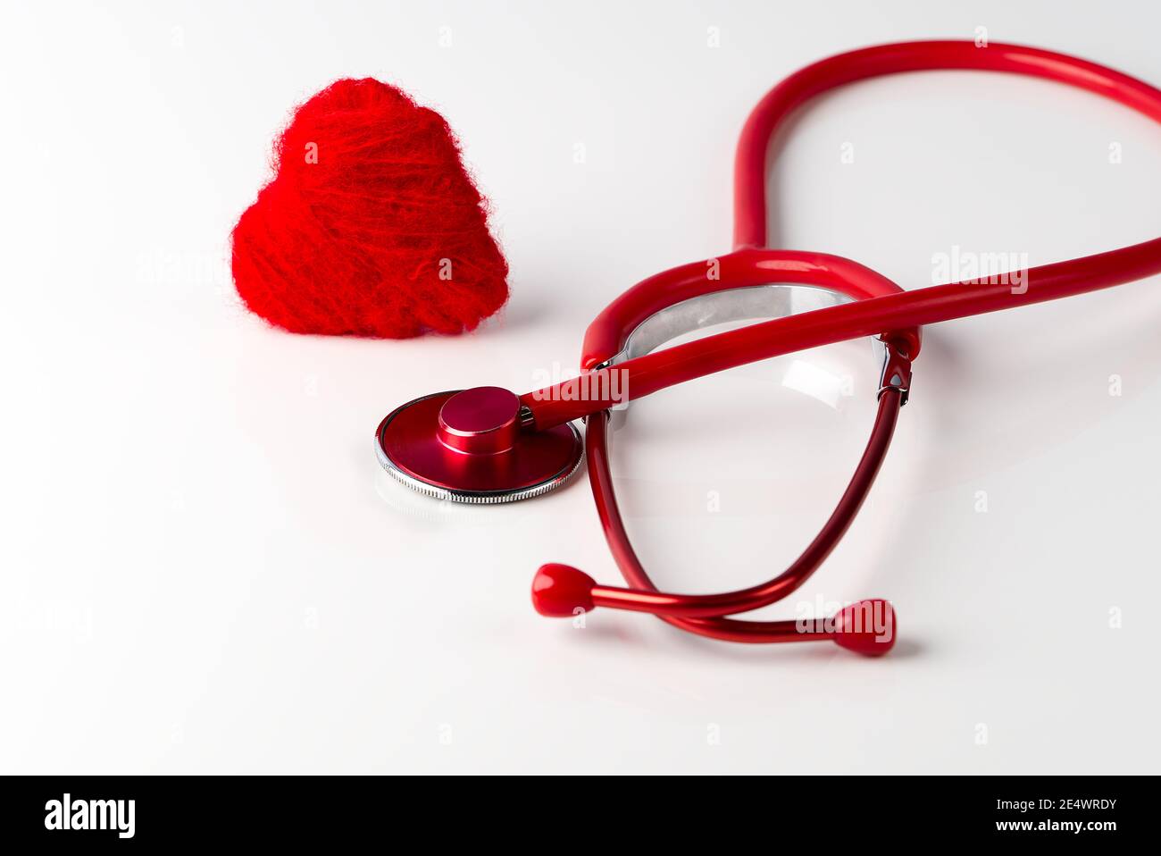 Rotes Herz und Stethoskop auf weißem Hintergrund. Integritätsprüfung. Stockfoto