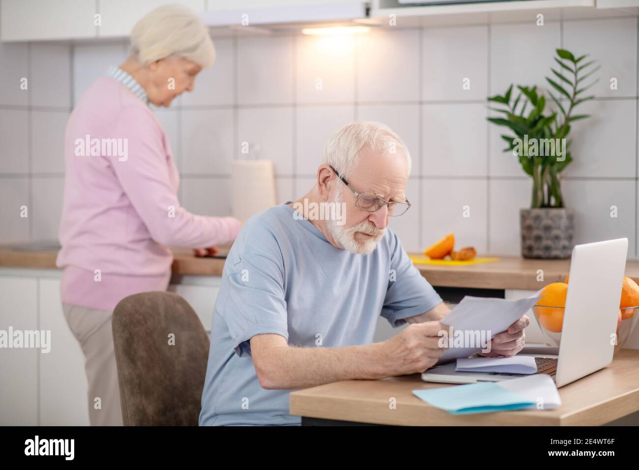 Bärtiger älterer Mann, der etwas liest und ernst aussieht Stockfoto