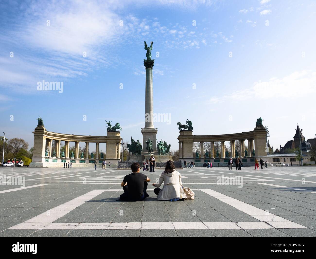Budapest, Ungarn - 05. April 2012: Das junge Paar sitzt in der Mitte des Heldenplatzes vor der Säule, die von der Statue des Erzengels G gekrönt wird Stockfoto