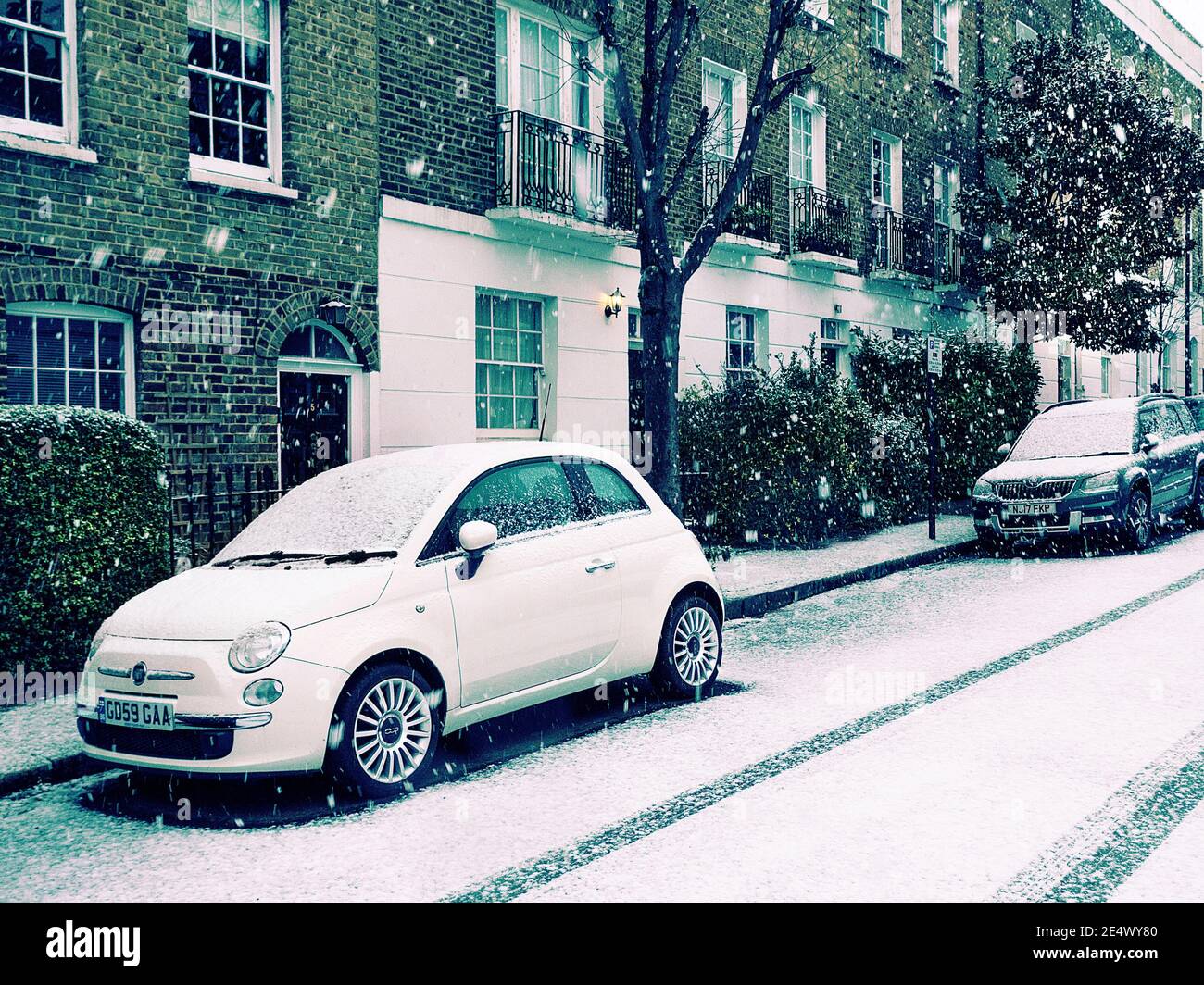 Fiat 500 geparkt auf einer schneebedeckten Straße i London VEREINIGTES KÖNIGREICH Stockfoto