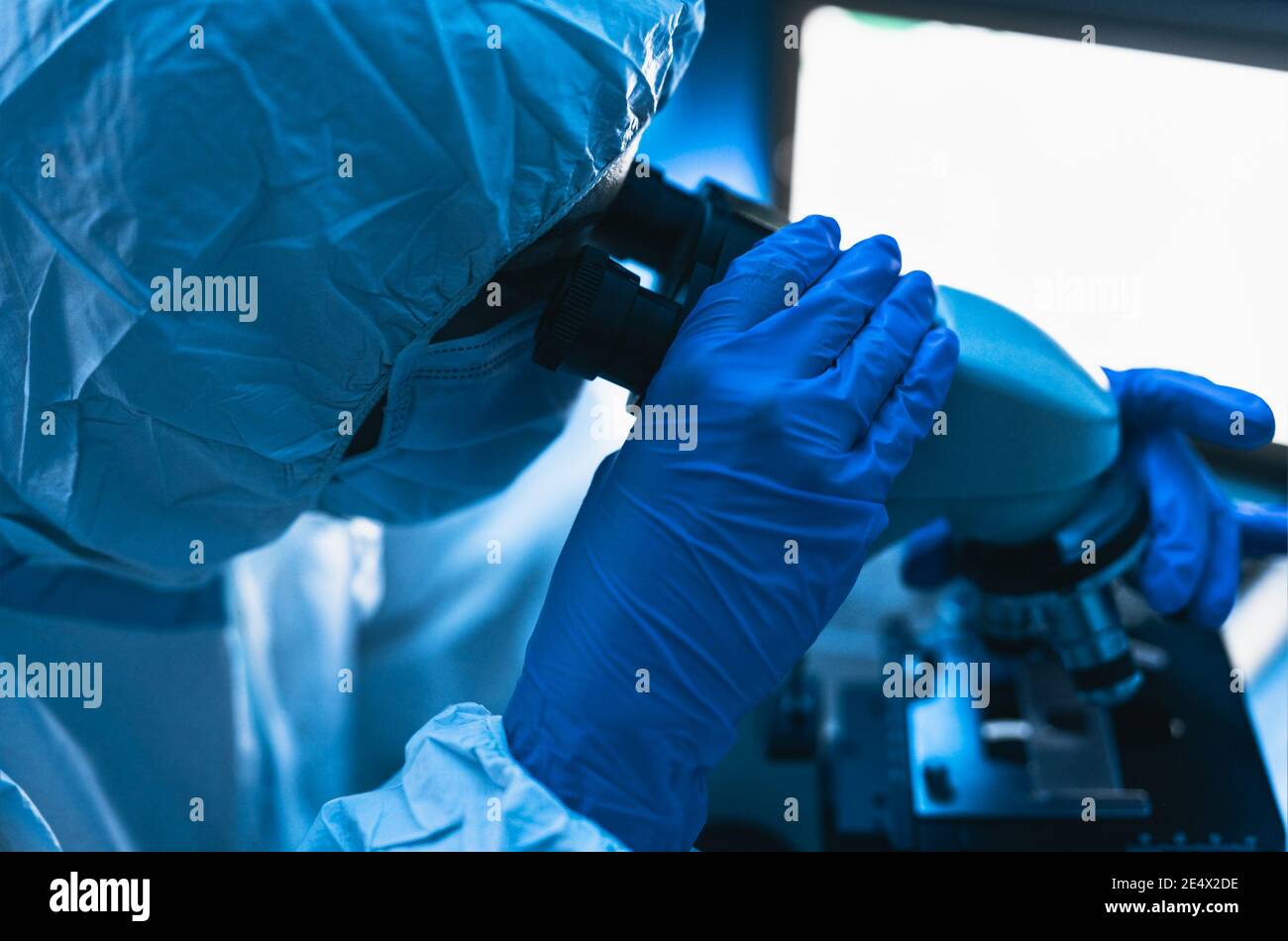 Junge Wissenschaftler arbeiten im Labor Untersuchung Coronavirus durch Mikroskop - Wissenschaft und Technik Konzept Stockfoto