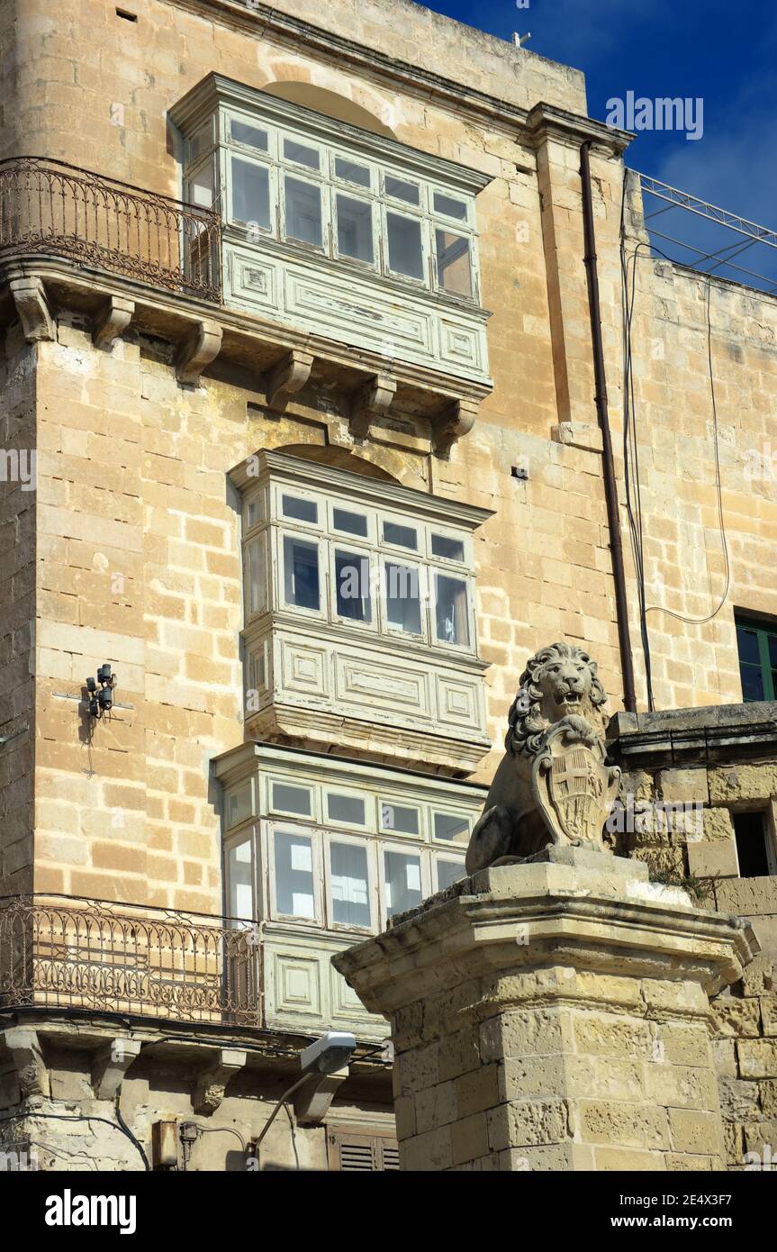 Traditionelle Holzbalkons und De Vilhena Löwenstatue in der East Street, Valletta Stockfoto