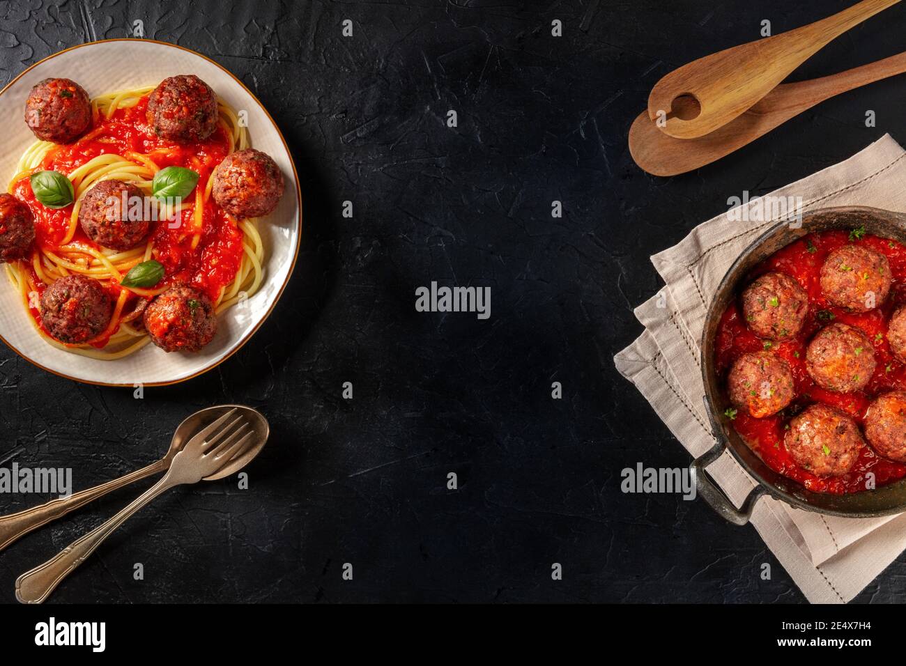 Fleischbällchen Bannerdesign. Fleischbalsam mit Pasta, mit Tomatensauce und Kräutern, darüber liegend flach auf einem dunklen Hintergrund mit Kopierraum erschossen Stockfoto