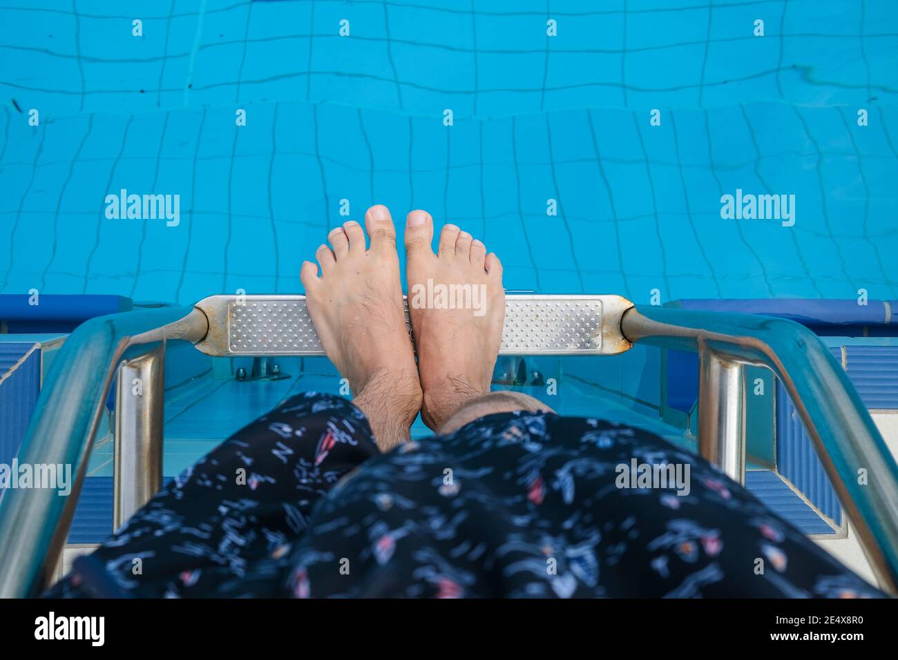 Blick nach unten Standpunkt eines Mannes Füße auf Leiter des Schwimmbades Stockfoto