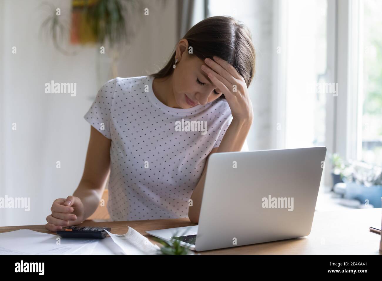 Besorgte junge Frau, die mit Finanzpapieren arbeitet, die Schulden herausfinden Stockfoto