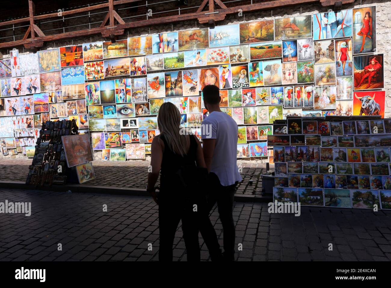 Krakau. Krakau. Polen. Touristen, die sich die Bilder ansehen, die zum Verkauf in der Kunstgalerie an der alten Stadtmauer ausgestellt sind. Stockfoto