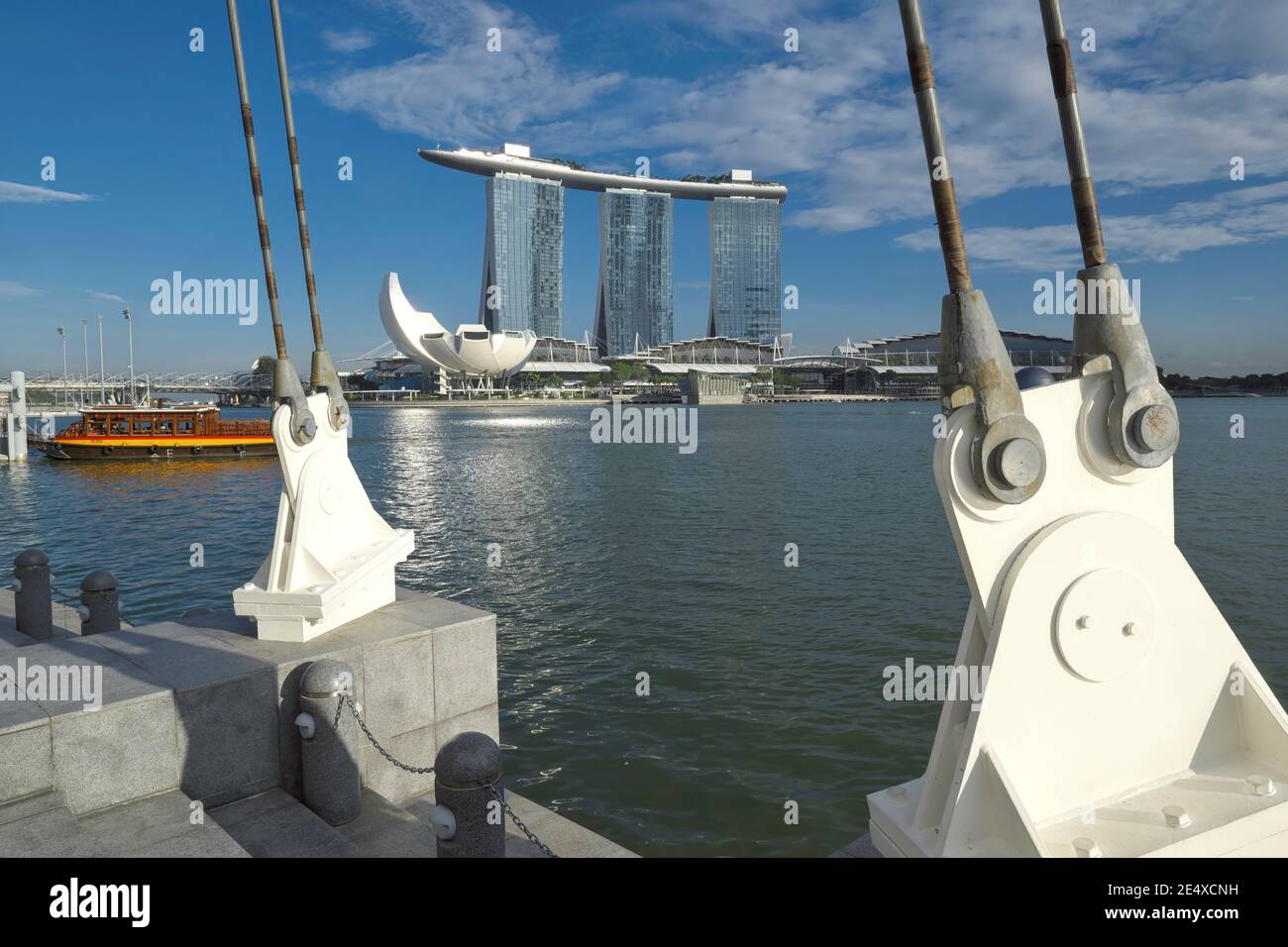 Blick von Esplanade, Singapur, über Marina Bay zum Wahrzeichen Marina Bay Sands Hotel und ein Ausflugsboot, das an einem angedockt ist Stockfoto