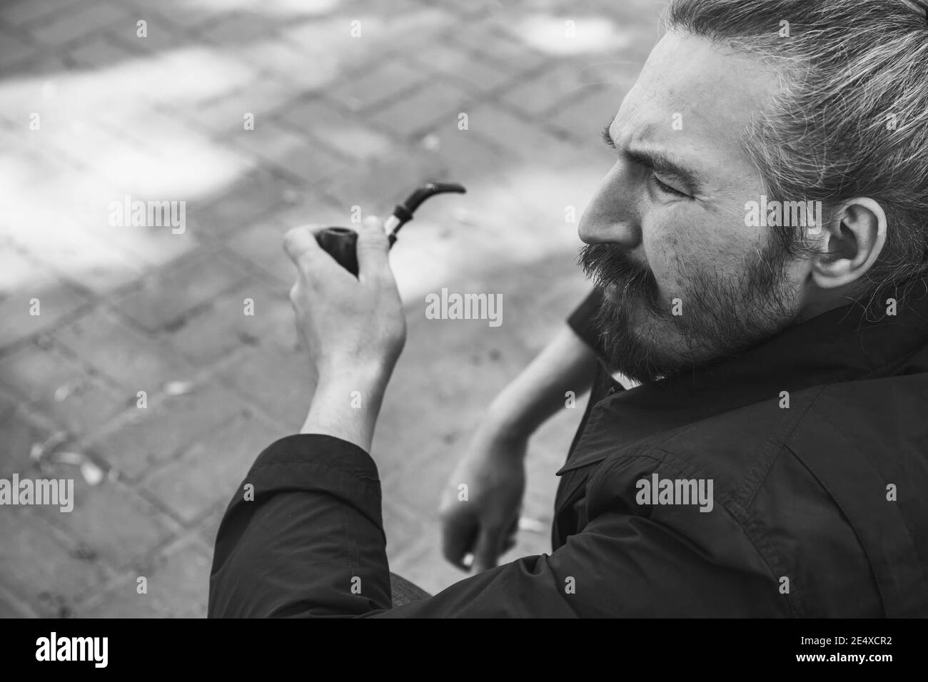 Bärtiger Mann mit Rauchpfeife, schwarz-weißes Profilportrait mit selektivem Fokus Stockfoto