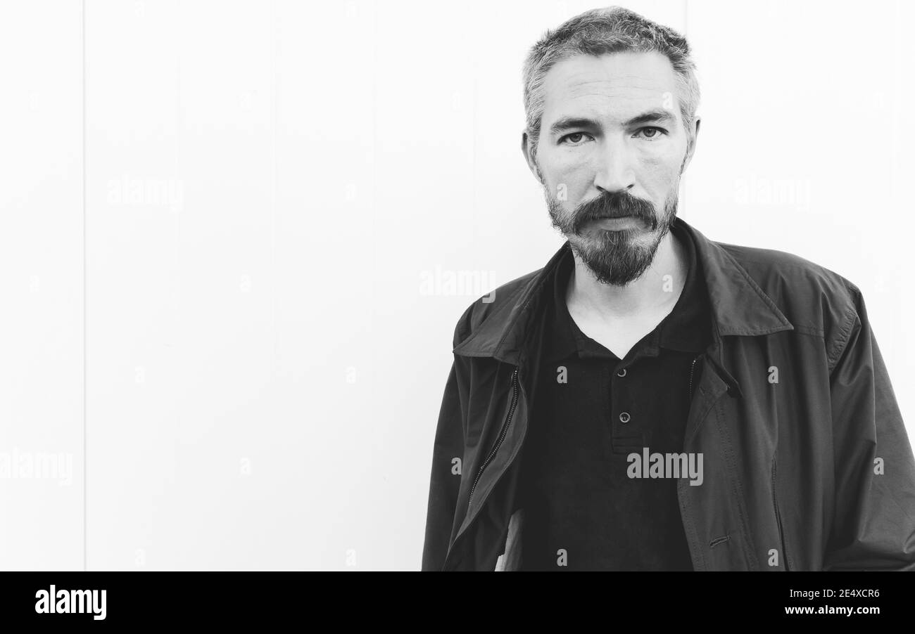Schwarz-Weiß-Porträt von schweren jungen Mann über weiß Wand Stockfoto