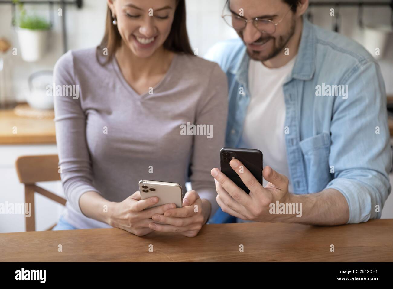 Junger Mann und Frau mit Mobiltelefonen, die Daten über WLAN teilen Stockfoto