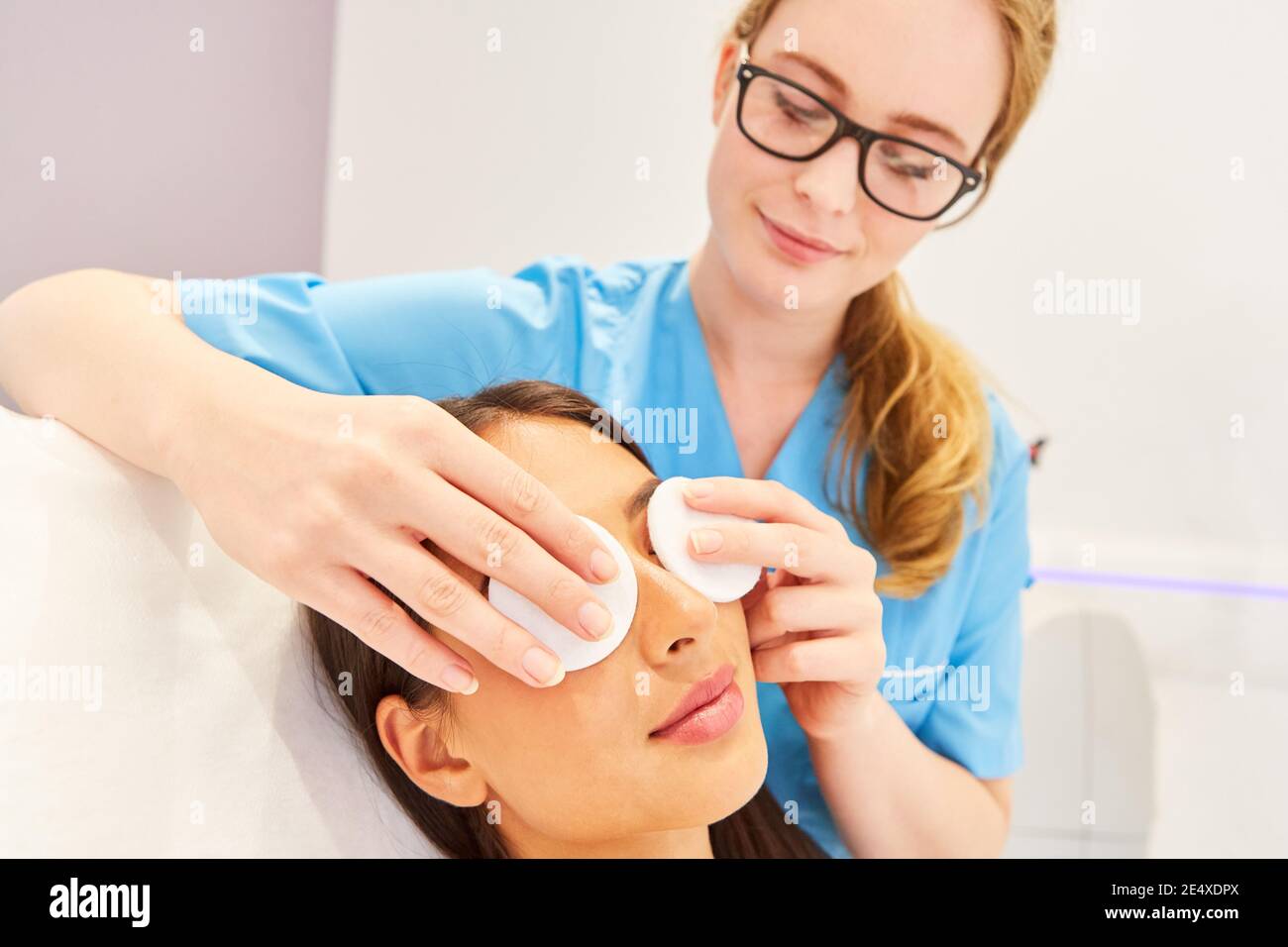 Kosmetikerin professionell Reinigung der Haut mit Wattepads auf einem Frauengesicht Stockfoto