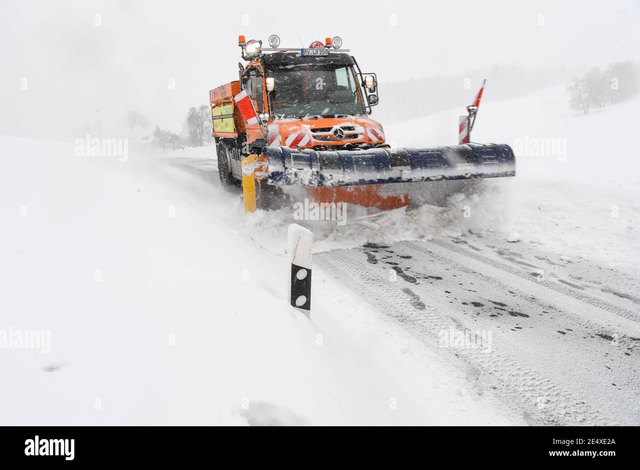 25. Januar 2021, Baden-Württemberg, Wangen im Allgäu: Ein Schneepflug räumt auf einer Landstraße in Karsee, einem Vorort von Wangen im Allgäu, den Schnee. Über Nacht hat es im Allgäu wieder angefangen zu schneien. Foto: Felix Kästle/dpa Stockfoto