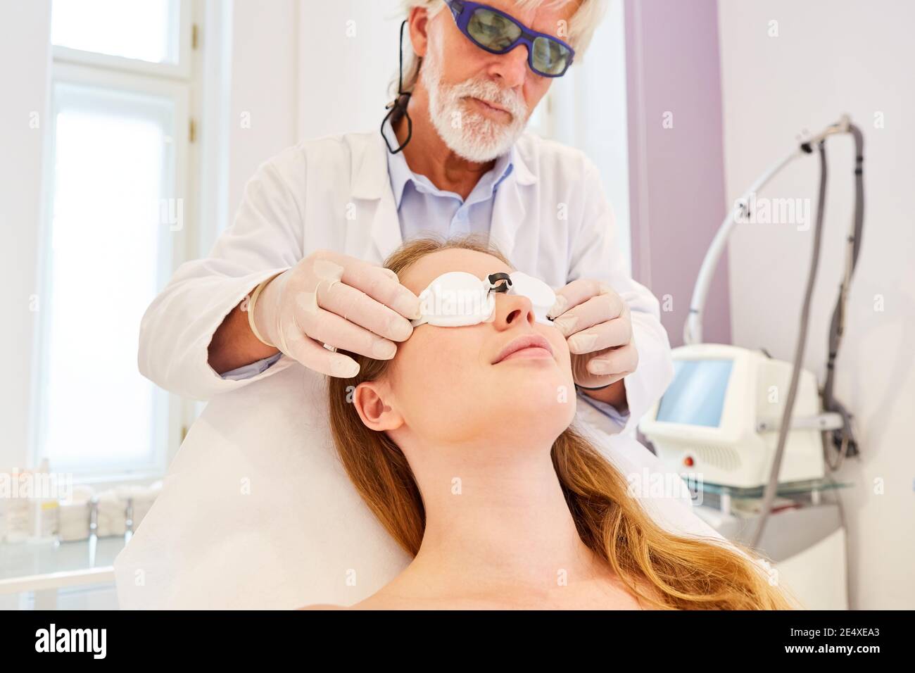 Dermatologe überprüft Schutzbrille am Patienten vor der Laserbehandlung auf Hautverjüngung Stockfoto