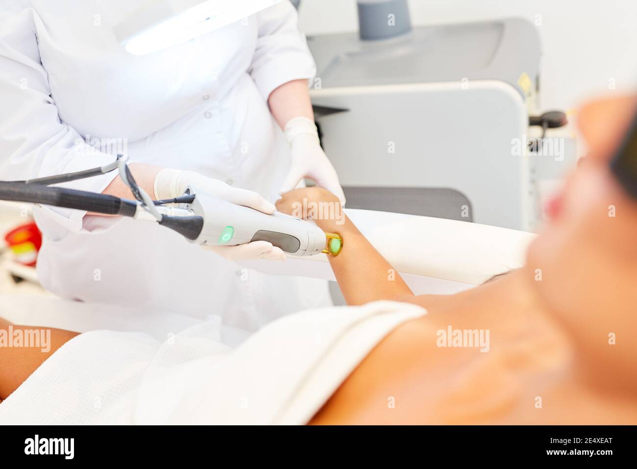 Dermatologe und Patient, der die Laserepilation am Unterarm mit durchführt Der Alexandrit-Laser Stockfoto