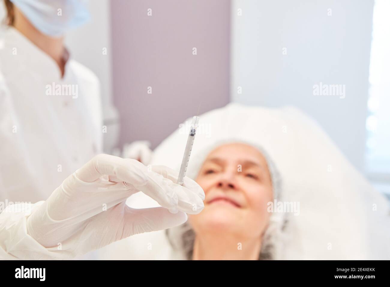 Ärztin hält Spritze mit Hyaluronsäure zur Faltenreduktion In der Schönheitsklinik Stockfoto
