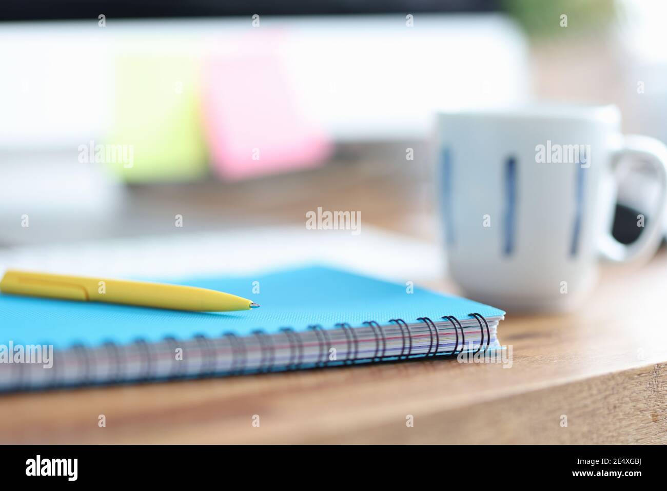 Auf dem Tisch ist Tasse neben Stift und Tagebuch für Hinweise Stockfoto