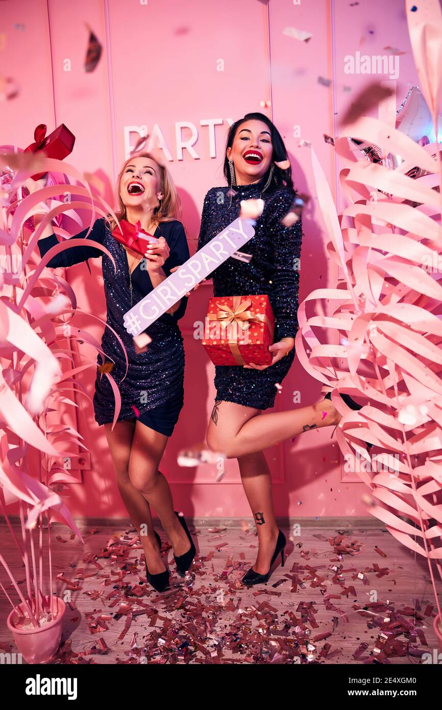 Fröhliche Damen halten Geschenkboxen in ihren Händen Stockfoto