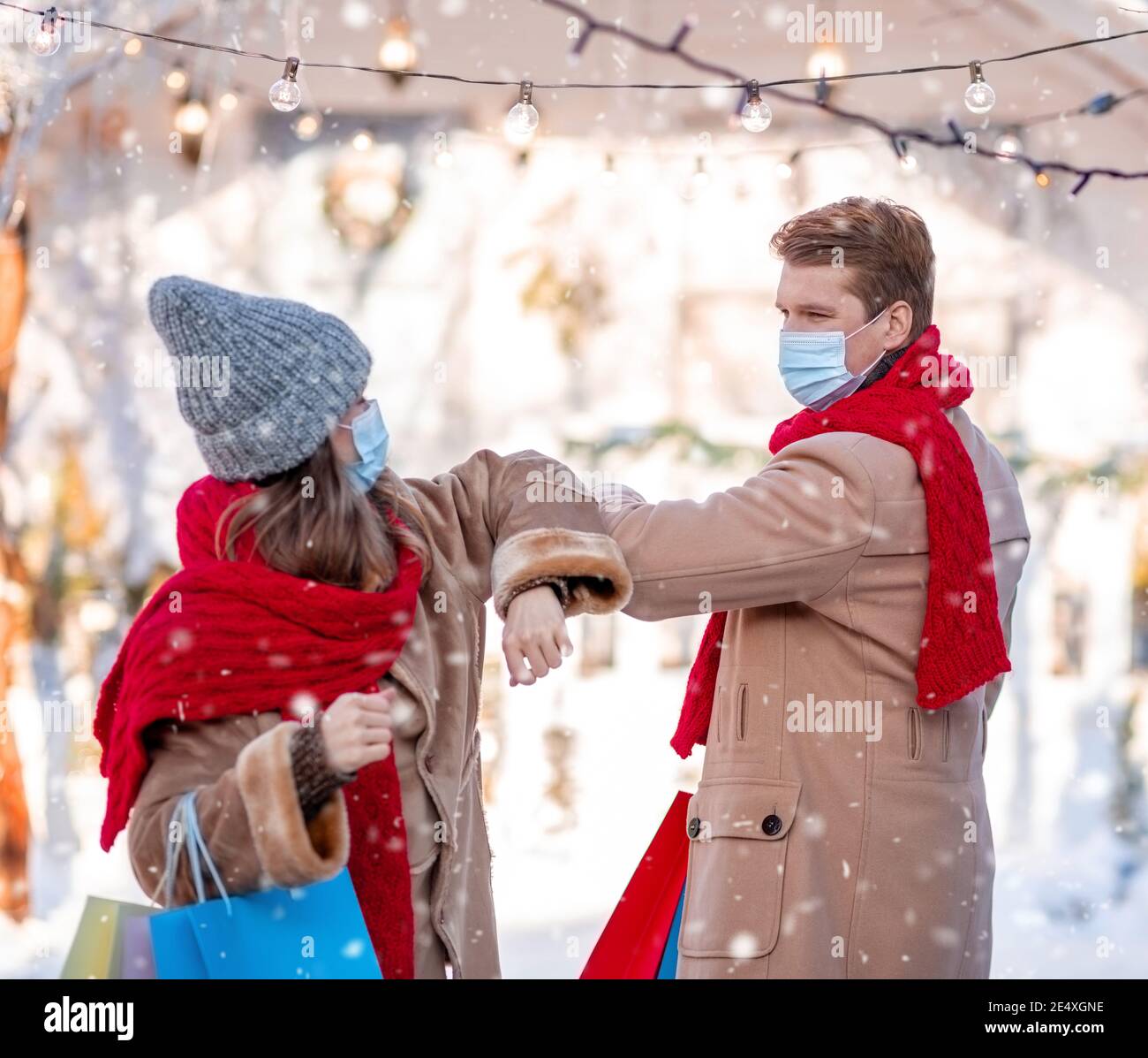 Mann und Frau im Gesicht Masken Gruß auf Winterstraße Stockfoto