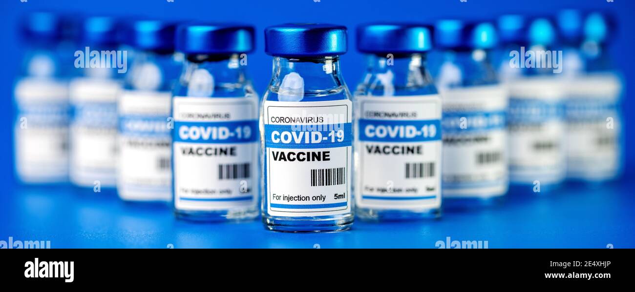 Covid-19 Impfstoff - Coronavirus Impfflaschen. Injektionsfläschchen auf blauem Hintergrund Stockfoto
