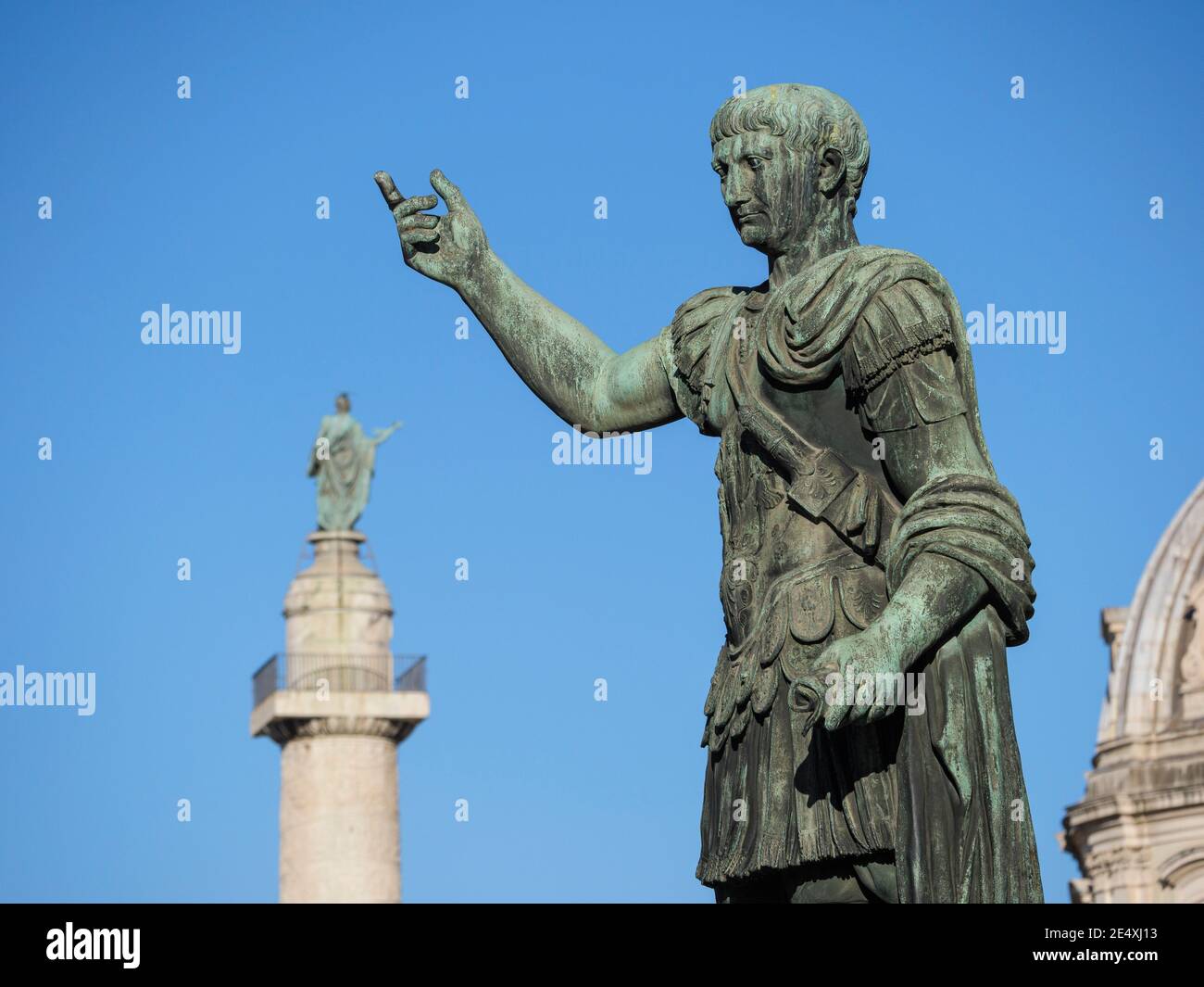 Rom. Italien. Bronzestatue des römischen Kaisers Trajan auf der Via dei Fori Imperiali, Trajans Säule ist im Hintergrund. 13. Kaiser des Römischen Reiches Stockfoto
