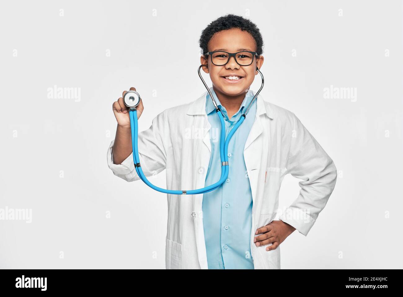 Afroamerikanischer Junge, der im Ärzteberuf mit einem Stethoskop spielt. Kinderhobby und zukünftige medizinische Beschäftigung. Weißer Hintergrund Stockfoto
