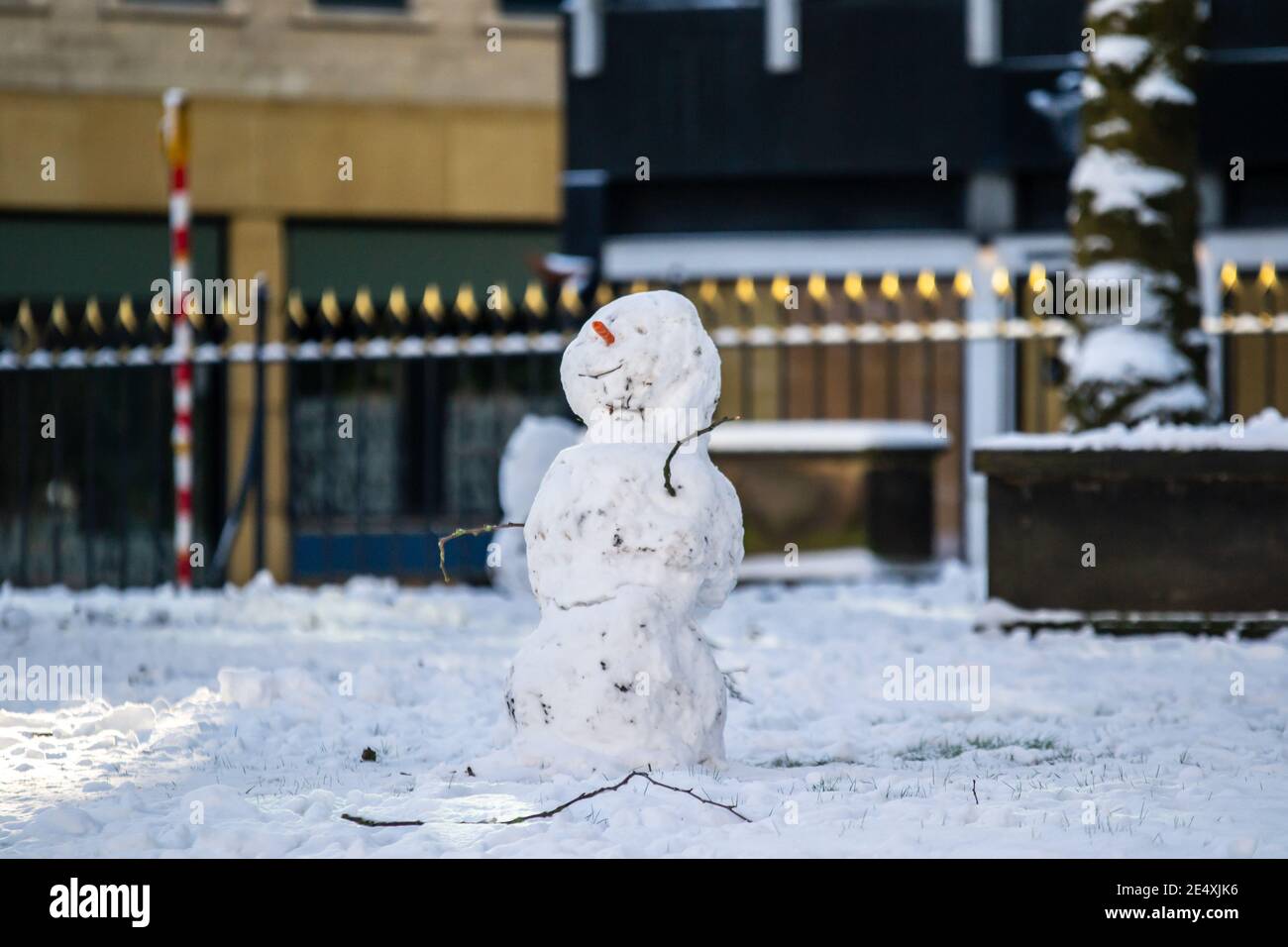 Birmingham, West Midlands, Großbritannien. 25. Januar 2021 - EIN fröhlicher Schneemann sitzt in einem Birmingham Park nach einem Tag Schnee. Kredit: Ryan Underwood / Alamy Live Nachrichten Stockfoto