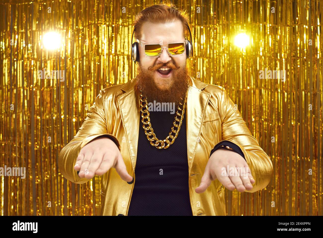 DJ in goldglänzender Jacke, Kopfhörern und cooler Sonnenbrille mit Musik im Nachtclub Stockfoto