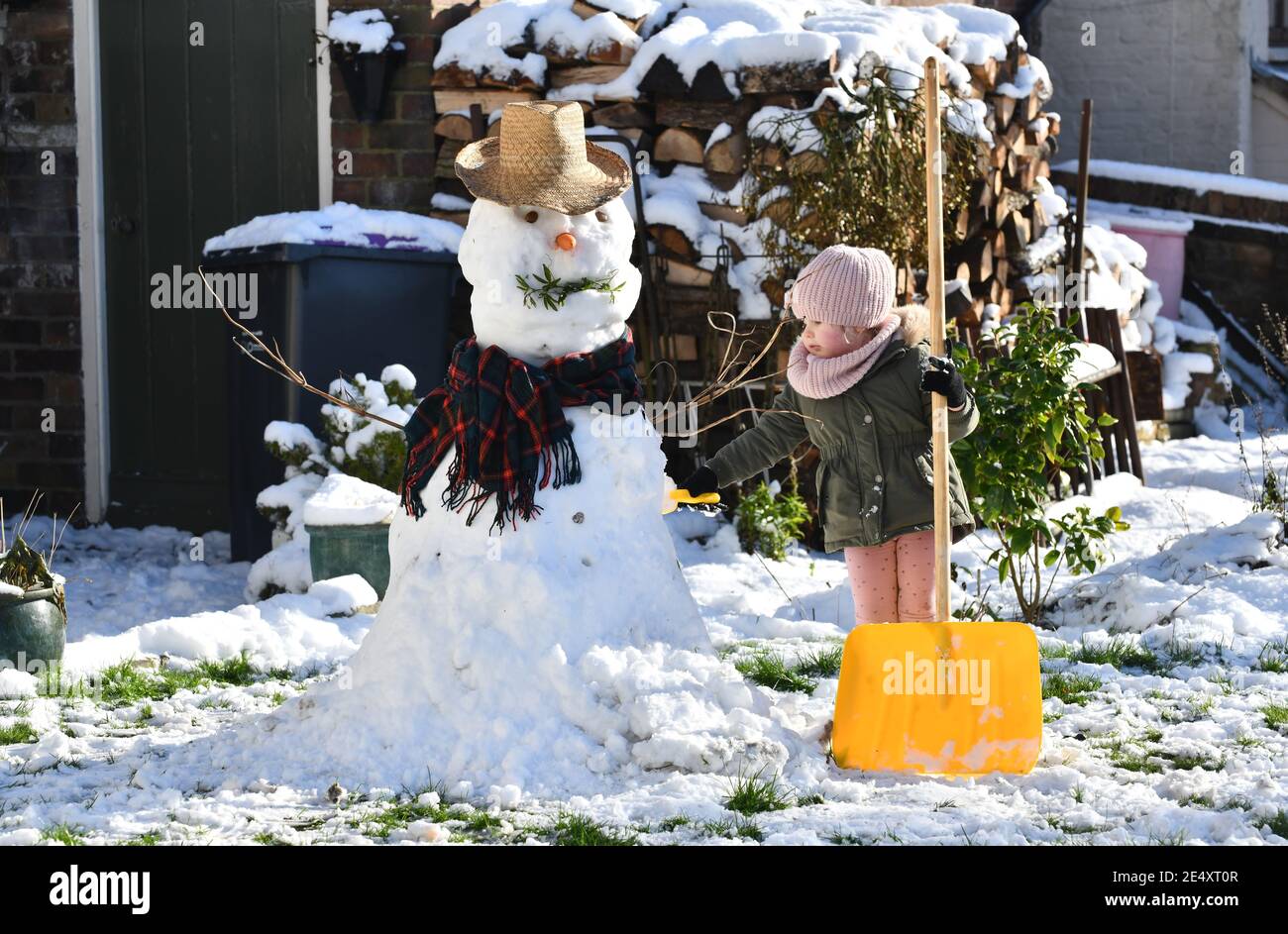 Ironbridge, Shropshire, Großbritannien 25. Januar 2021. Einen Schneemann bauen. Ironbridge Familie beweisen Winterwetter kann Spaß machen, wie sie den letzten Schliff zu sehr smart Schneemann setzen. Kredit: David Bagnall/Alamy Live Nachrichten Stockfoto