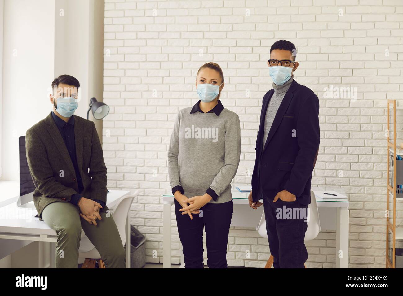 Die Menschen tragen Gesichtsmasken im Büro, kümmern sich um die Gesundheit der Kunden und Mitarbeiter Stockfoto