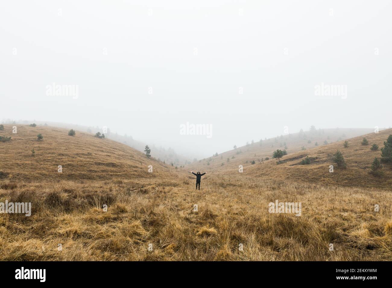 Junger Mann, der an einem nassen Wintermorgen die Natur erkundet Die Berge Stockfoto