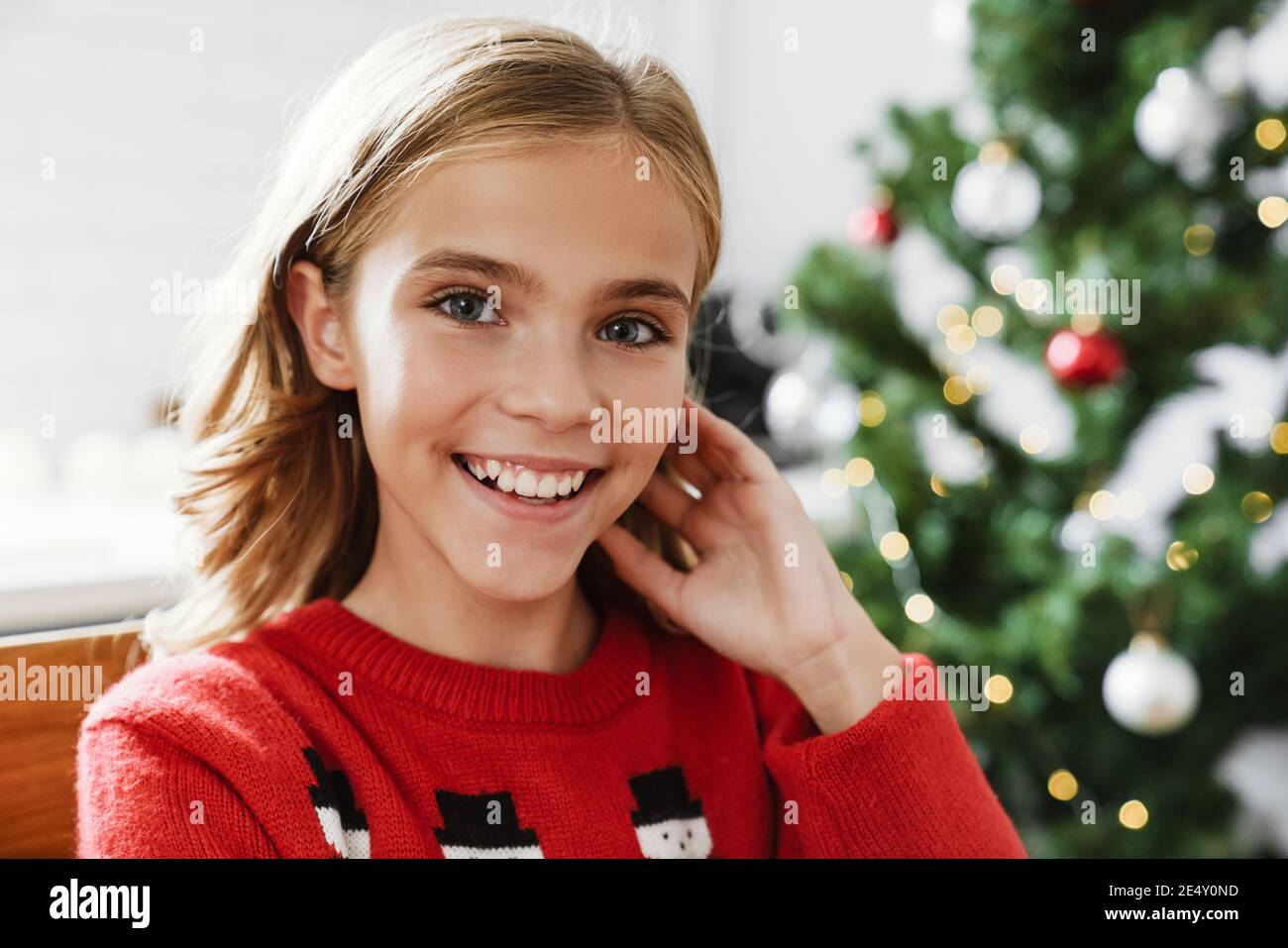 Glücklich kaukasischen Mädchen lächelnd und Blick auf Kamera in gemütlich Zimmer Stockfoto