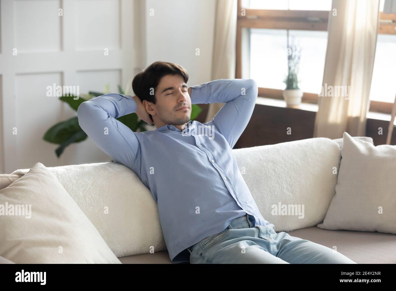 Nahaufnahme friedlicher Mann, der sich mit geschlossenen Augen auf der Couch entspannt Stockfoto