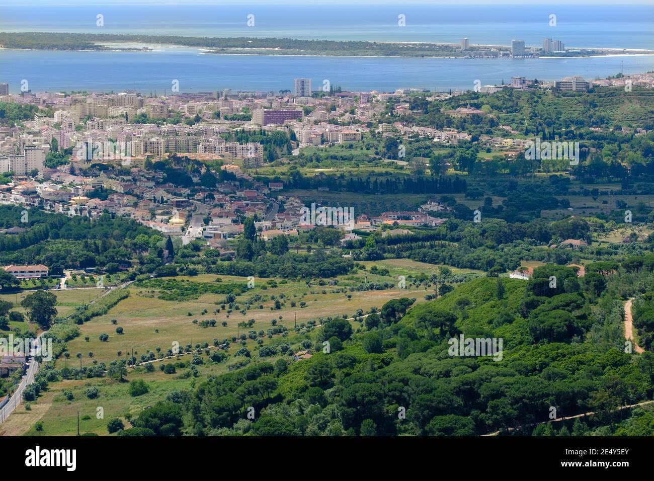 Berg Hügel mit Bäumen bedeckt mit Stadt im Hintergrund Neben dem Strand und einer Insel Stockfoto