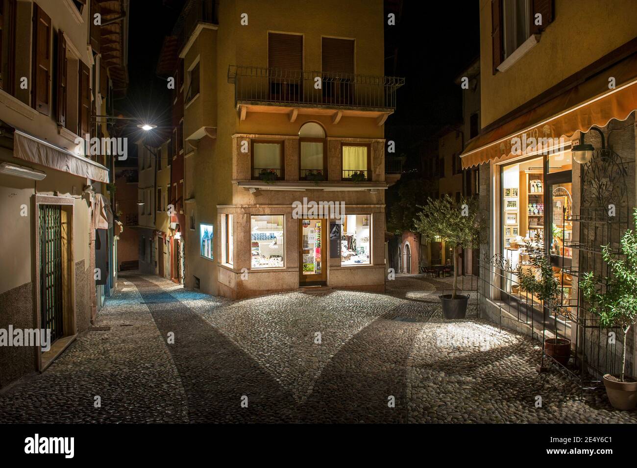 Geschäfte und gepflasterte Straßen in Malcesine, am Ostufer des Gardasees in der Region Venetien in Italien. Stockfoto