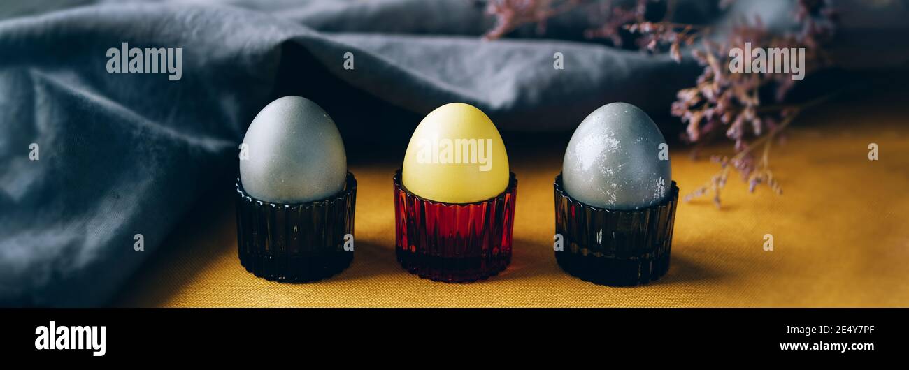 Bio natürlich gefärbte gelbe und graue Ostereier. Stilvolles Urlaubsdekor. Webbanner Stockfoto